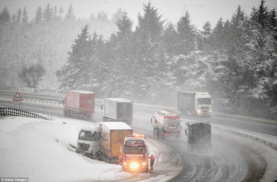 A jackknifed lorry is recovered on the M74 today after motorists spent the night stranded on the road in Abington, Scotland
