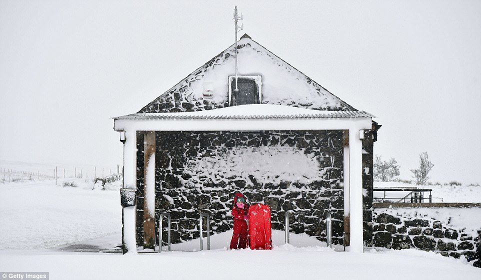 Brigid Stitt prepares to go sledding in the snow in Belfast today as Northern Ireland was hit by school closures