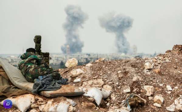 A pro-government fighter observes smoke rising on the horizon in Idlib province