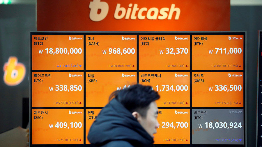 man walks past an electric board showing exchange rates of various cryptocurrencies including Bitcoin  Kim Hong-Ji / Reuters