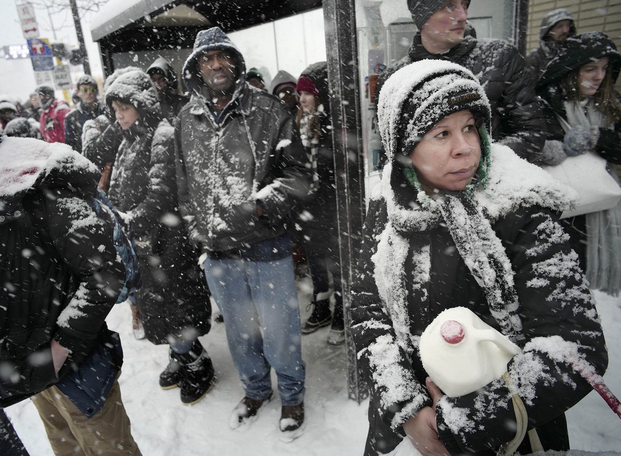 Click to enlarge Commuters downtown waited for the bus early in the afternoon in the hope of beating the bad weather including Timmy Johnson, far right, who picked up some milk at Target.