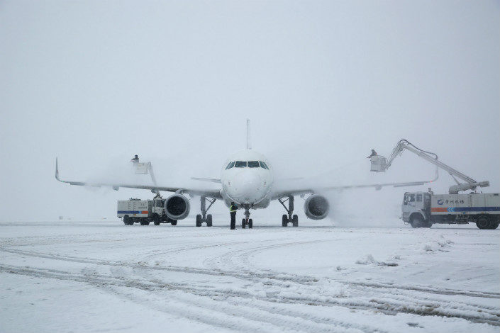Click to enlarge Airport crews remove snow from an airplane at Changzhou airport, in Jiangsu province, on Jan. 25, 2018.