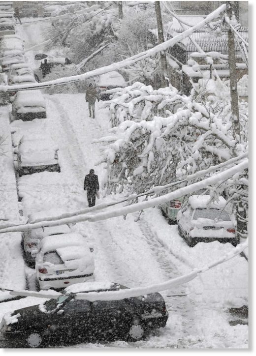 Click to enlarge An Iranian man walks amid the snow in the capital Tehran