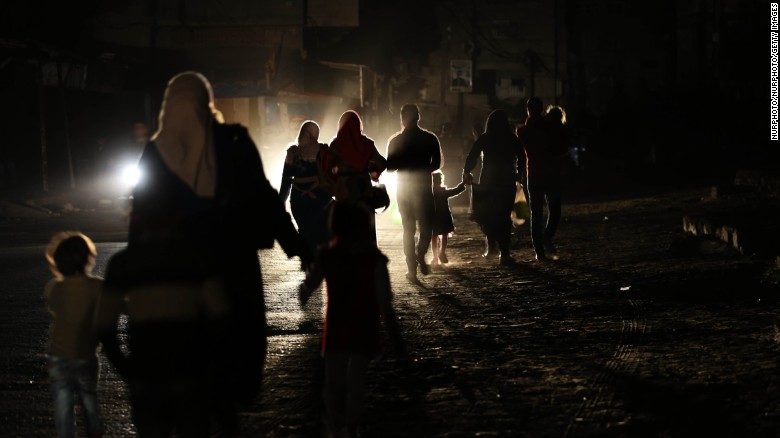 Gazans walk along a darkened street during a power outage on April 14.
