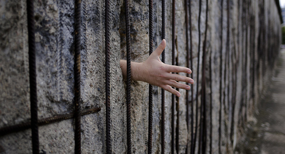 hand through remains of Berlin Wall