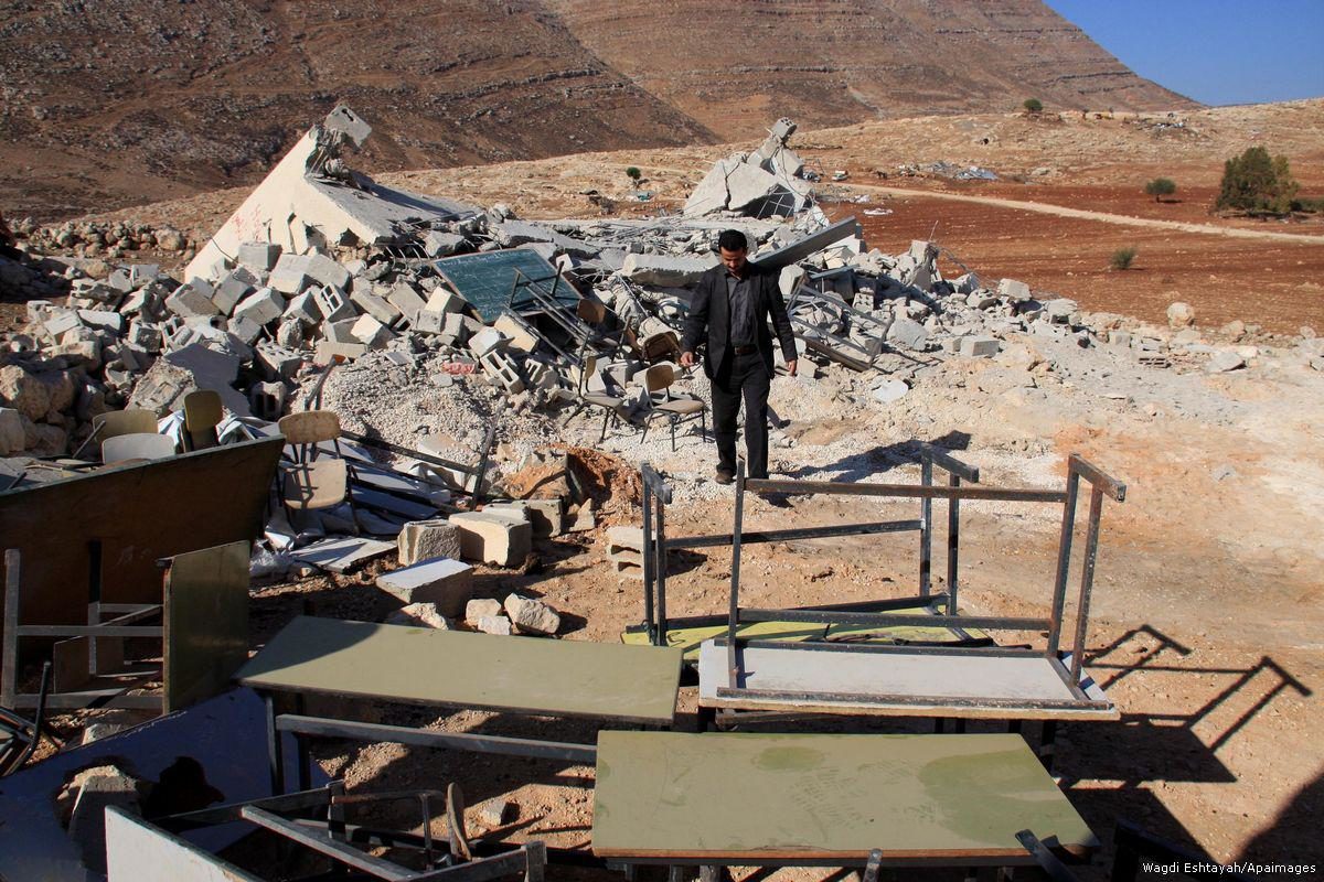 Click to enlarge A Palestinian man walks near a school