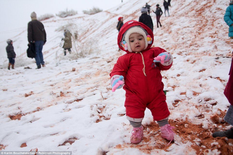 Click to enlarge Do you wanna build a snowman? A young resident is making the most of the rare snowfall while playing on the sand dunes