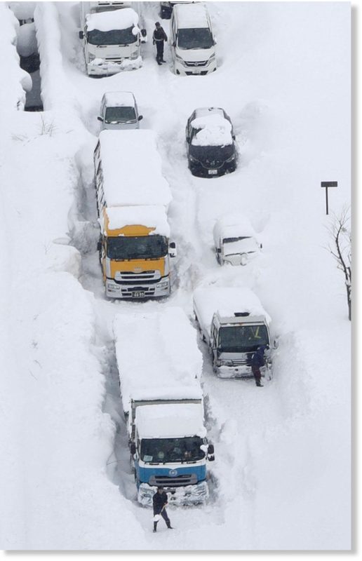 Click to enlarge An aerial photo shows cars and trucks buried in snow and stranded on Route 8 in Sakai, Fukui Prefecture, on Wednesday.