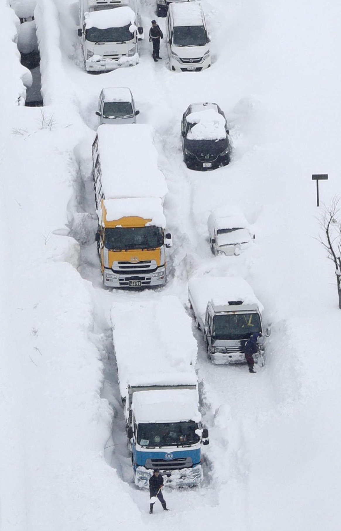 An aerial photo shows cars and trucks buried in snow and stranded on Route 8 in Sakai, Fukui Prefecture, on Wednesday.