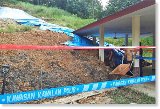 Men clear an area affected by a landslide