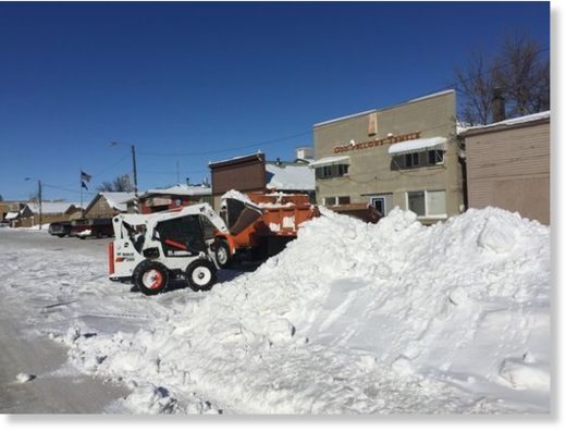 Click to enlarge Tim LaBuea uses a Bobcat to load snow onto a truck driven by Larry Geyer in Big Sandy.
