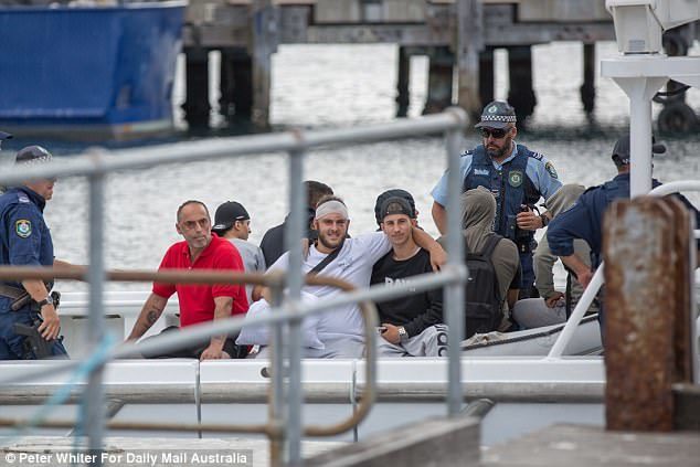 Click to enlarge One man was seen with his head wrapped in a bandage as they were arrested by police in the early hours of Friday morning