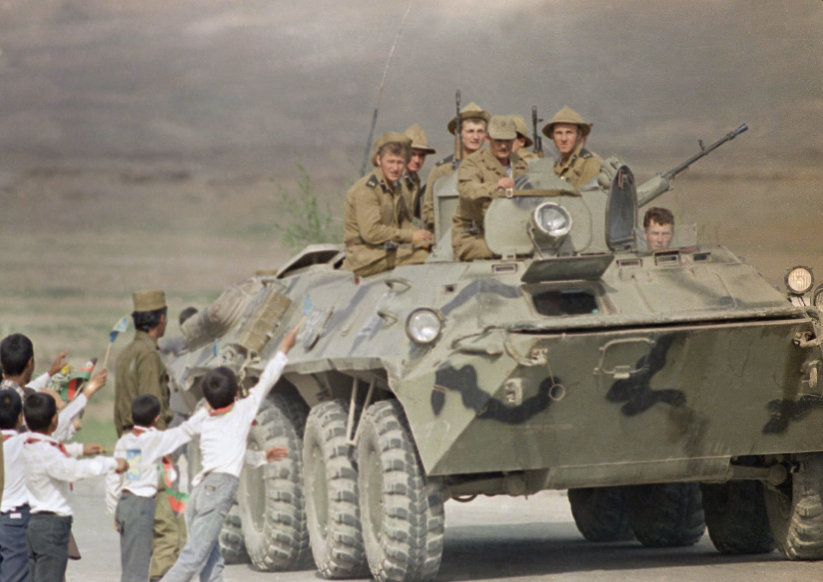 Click to enlarge Afghan children and a soldier bid farewell to Soviet soldiers