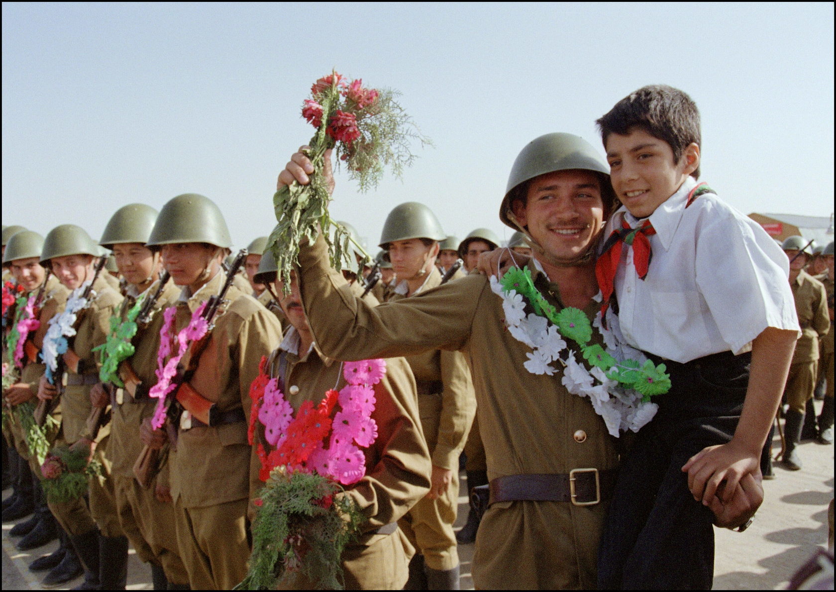 Red Army soldier holding an young Afghan pioneer