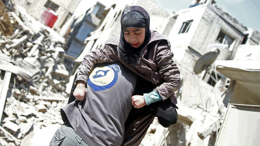 A member of the controversial White Helmets group holds an injured woman