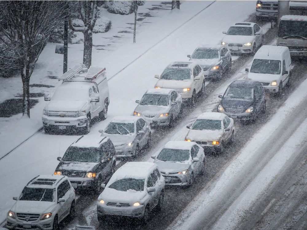 Motorists sit in traffic as snow falls in Vancouver, B.C., on Friday February 23, 2018. Environment Canada issued a snowfall warning for Metro Vancouver with 10 to 20 centimetres of snow expected.