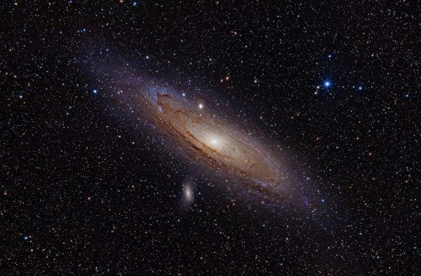 The Andromeda Galaxy, along with two of its satellites: M110 can be seen below the plane, and M32 as the small, round object just above it.