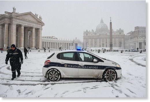 Local police patrol in front of St. Peters Basilica after the square in the Vatican was covered by snow on Monday