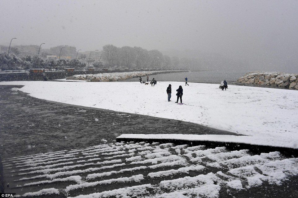 Local people came out to glimpse the unusual site of snow on the city's seafront