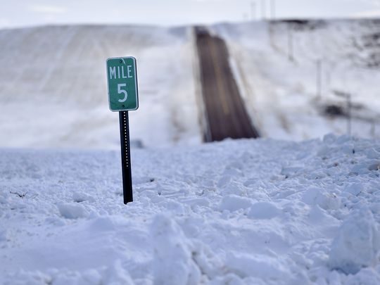 A mile marker is buried north of Cut Bank Wednesday. Snow and wind has made roads impassable at times making it difficult for ranchers to reach cattle.