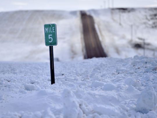 Click to enlarge A mile marker is buried north of Cut Bank Wednesday. Snow and wind has made roads impassable at times making it difficult for ranchers to reach cattle.
