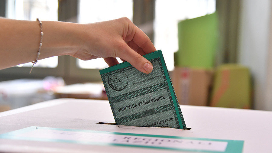 Click to enlarge A woman casts her ballot on March 4, 2018 at a polling station in Rome