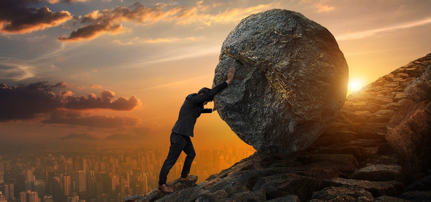 Click to enlarge man pushing boulder up a hill