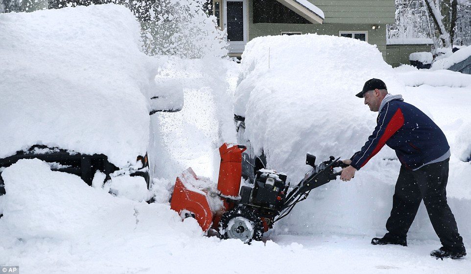John Visco is pictured clearing off his driveway in Derry, New Hampshire, after Wedneday night's storm covered the town in a blanket of snow