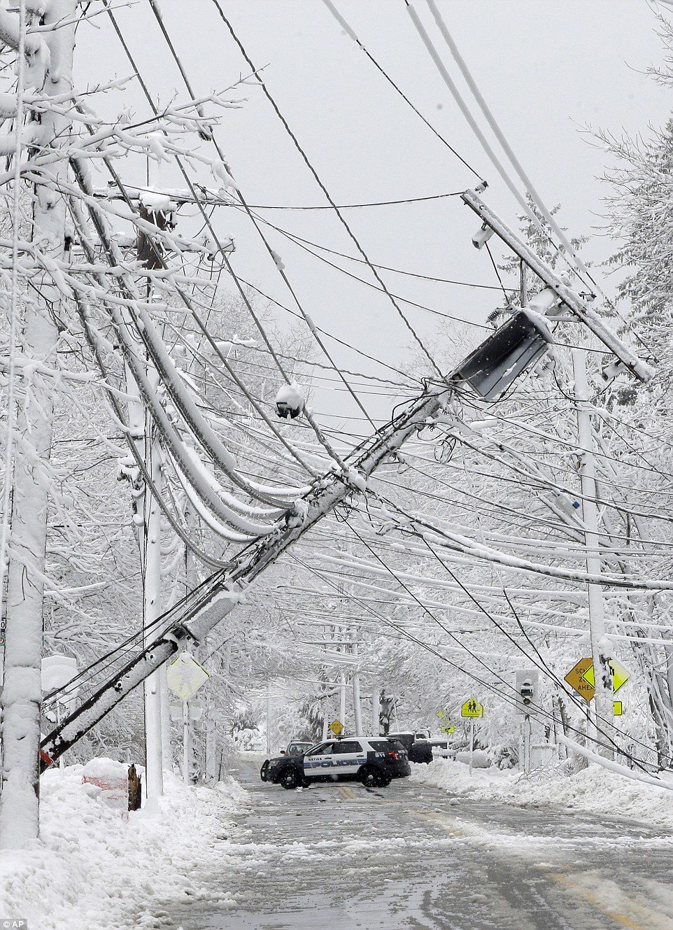 A police vehicle is pictured blocking off a road near dozens of downed power lines in Matic, Massachusetts, after the second storm in a week knocked out power for dozens in the town