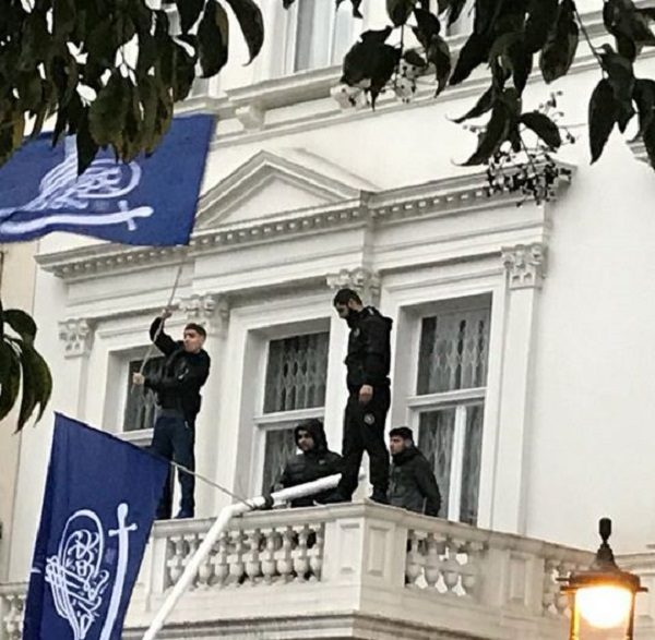 Men in black remove flag at Iran's embassy