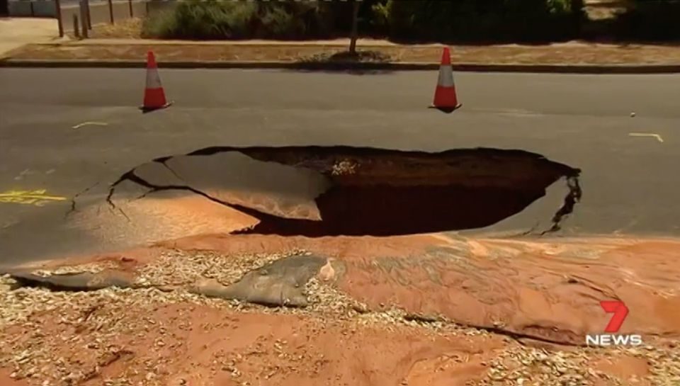Click to enlarge A giant sinkhole opened up outside one family's house.