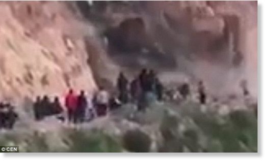 Click to enlarge In the footage, hundreds of people are gathered on a mountain road after earlier landslides made it hard to cross