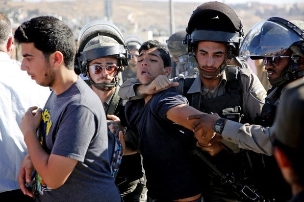 Click to enlarge Israeli border police detain a Palestinian youth
