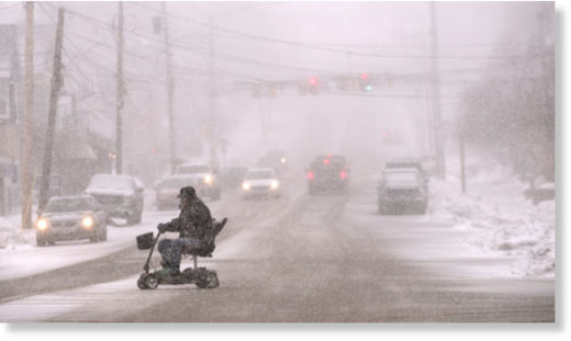 Click to enlarge A man rides an electric wheel chair on Union Street as heavy snow started falling in Bangor Tuesday afternoon.