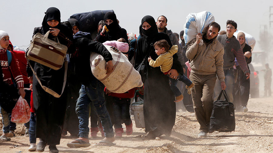Click to enlarge People walk with their belongings as they flee the rebel-held town of Hammouriyeh