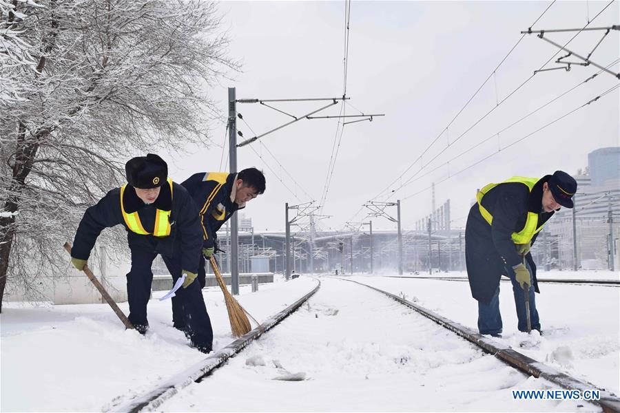 Workers remove snow from train tracks at Shenyang North Railway Station in Shenyang, northeast China's Liaoning province, March 15, 2018.