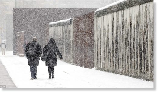Click to enlarge Berlin was particularly badly affected by the snow on Tuesday, with most of the city receiving a thick coating. Here a man and a woman walk alongside a section of the Berlin as the flakes fall