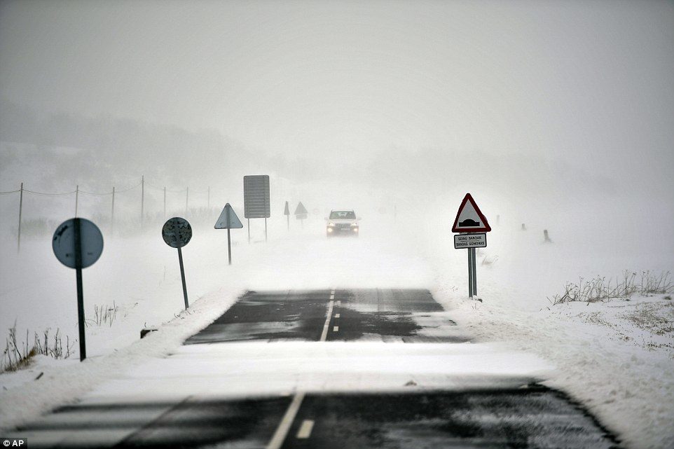 A car travels along a road covered by the snow near to Santa Cruz de Campezo, northern Spain, after the country was dusted with the white stuff