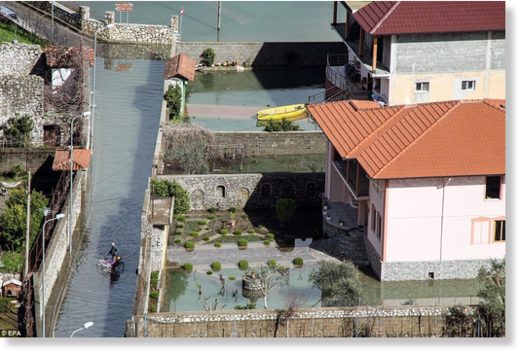 Click to enlarge An Albanian man rides on his bicycle in the flooded roads of Ajazem village near Shkoder, after the country was hit by heavy rainfall and melting snow