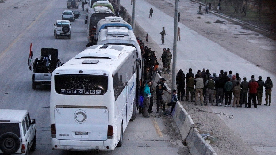 Rebel fighters gather and pray before they leave, at the city limits of Harasta