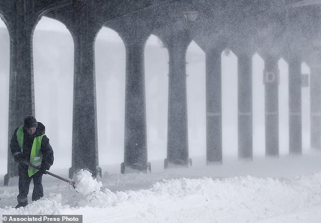 A municipal worker clears ice and snow from the platforms of the Gara de Nord, the main railway station in Bucharest, Romania, Friday, March 23, 2018.