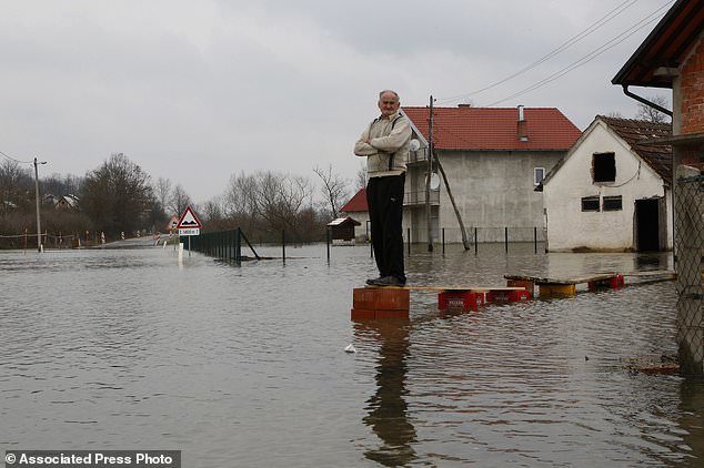 Bosnian Milan Ilic watches the level of flooded water from the Sava River in front of his house in the village of Bistrica near Gradiska, 260 kms northwest of the Bosnian capital of Sarajevo, Thursday, March 22, 2018.
