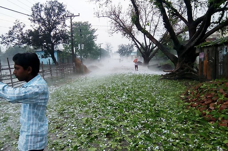 A man takes pictures of hailstones fallen in Matsari area of Durga Bhagawati Rural Municipality, in Rautahat district, on Friday, March 30, 2018.