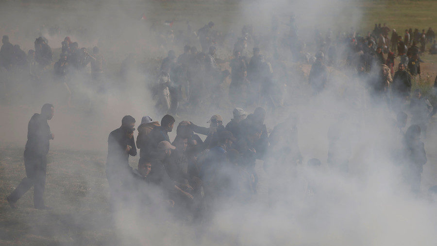 Palestinians run from tear gas fired by Israeli troops