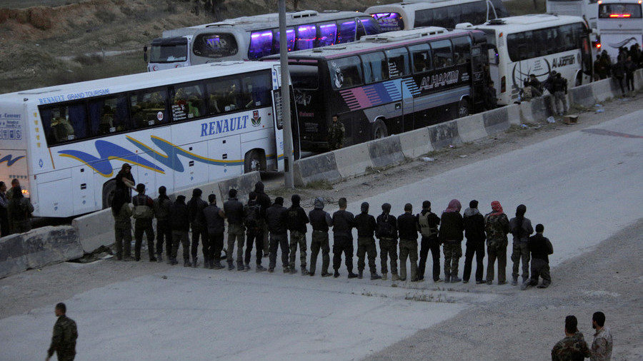 Rebel fighters pray before they are evacuated outside Harasta in eastern Ghouta