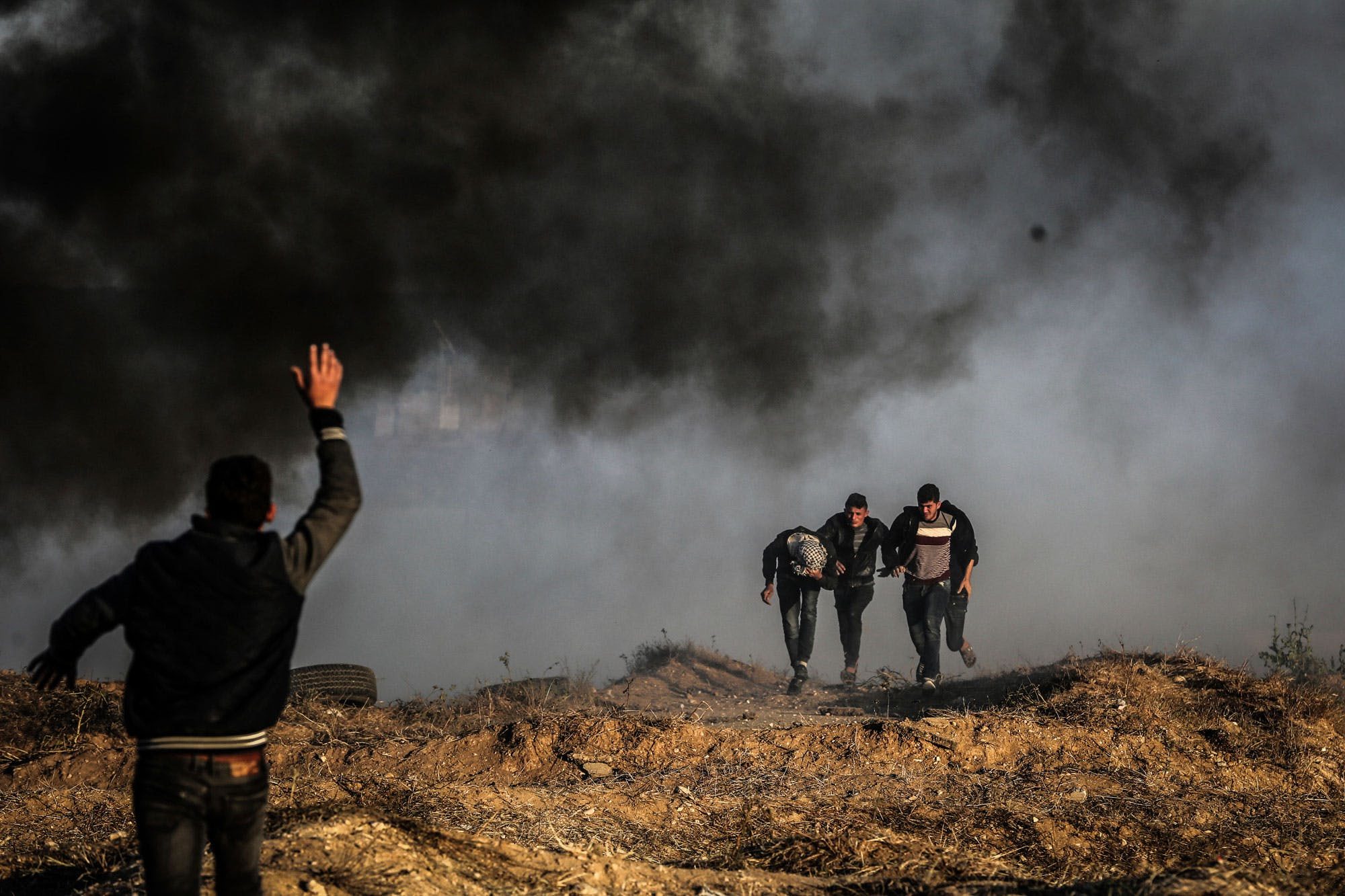 Click to enlarge Palestinians protesters run for cover