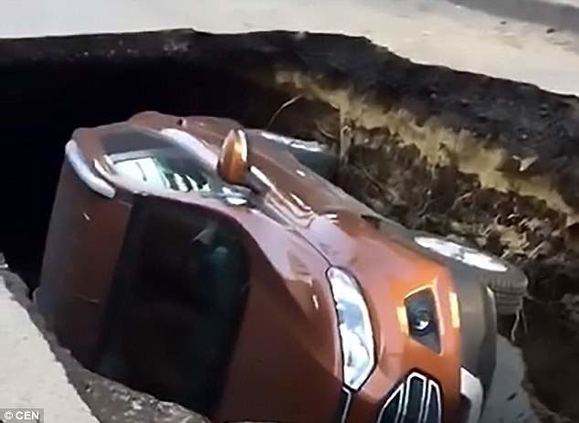 Incredible footage from the scene shows the stricken car lying on its side in the sinkhole