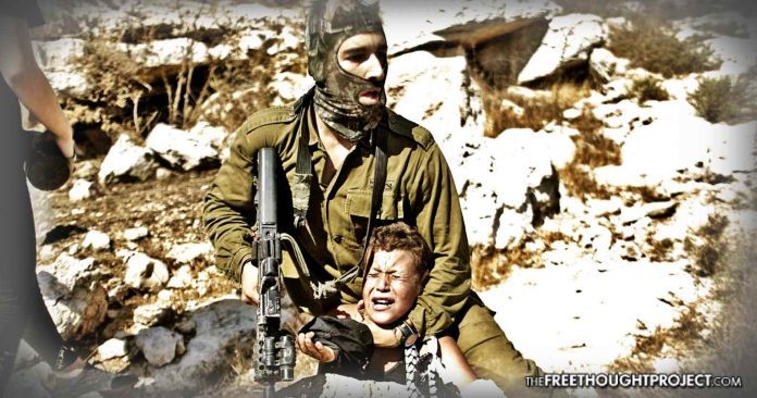 Israeli soldier detaining Palestinian boy