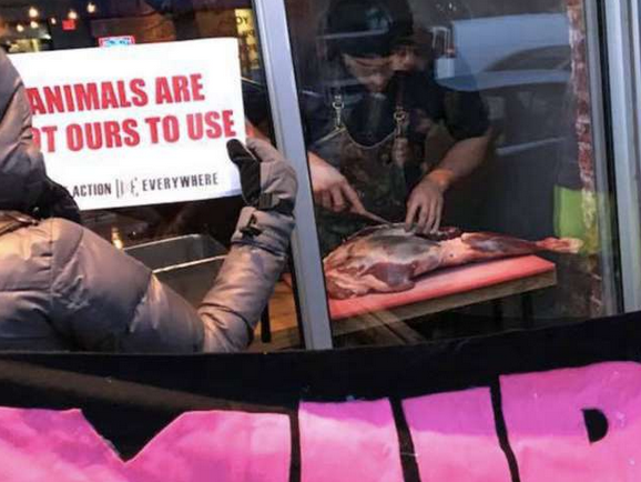 Click to enlarge Bar in Toronto, butchers a deer leg while vegans protest outside on Friday, March 23, 2018.