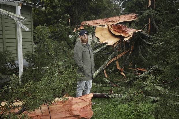 Matt Petuha in front of his family's rented Te Puke home surrounded by the remains of a tree struck by lightning.